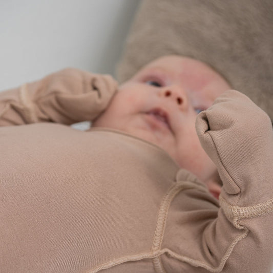 Baby With Eczema On Face Wearing Mahogany Rose Baby Bodysuit From SOOTHLA With Anti-scratch Mittens.